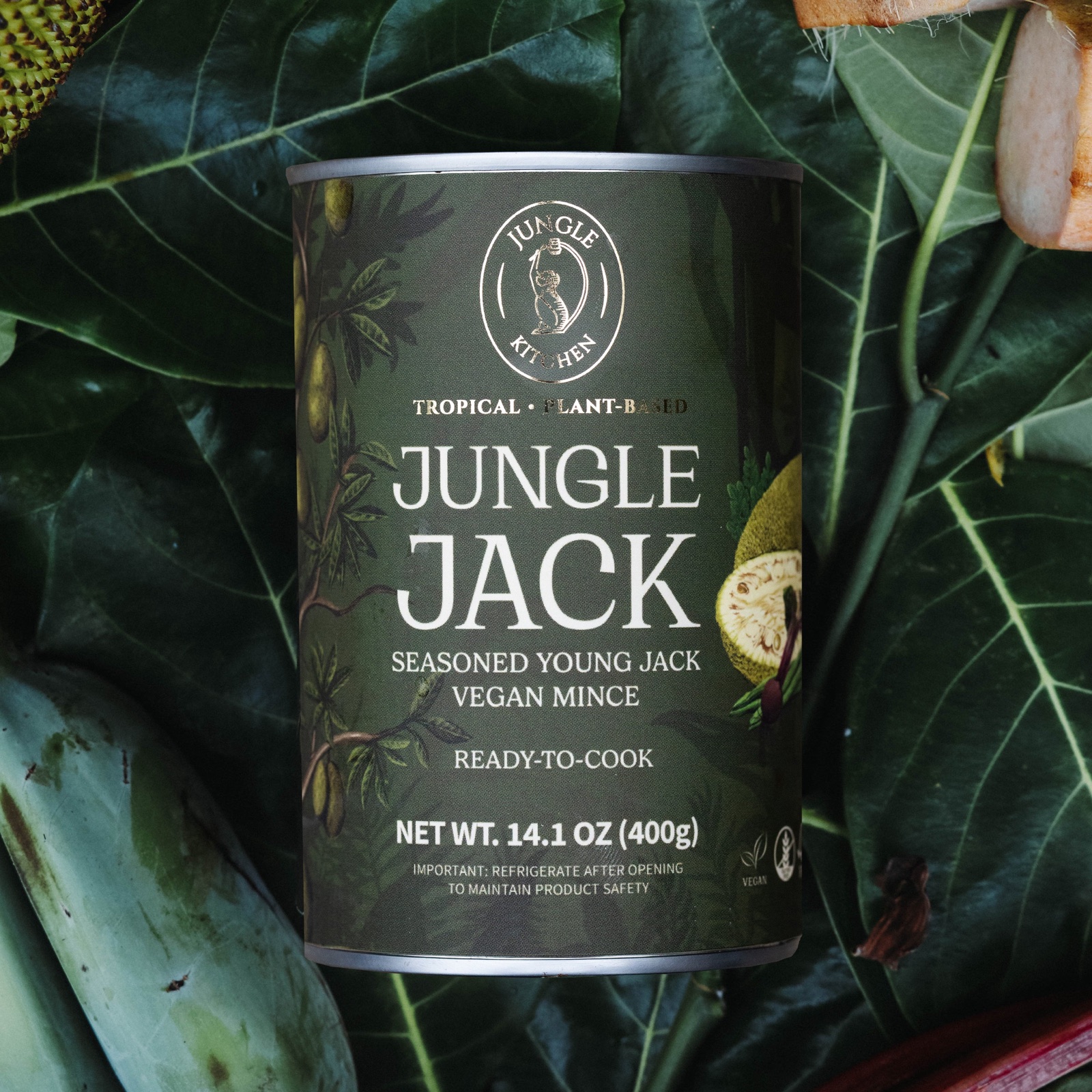 A tin of Jungle Jack among jackfruit leaves and raw tropical plants